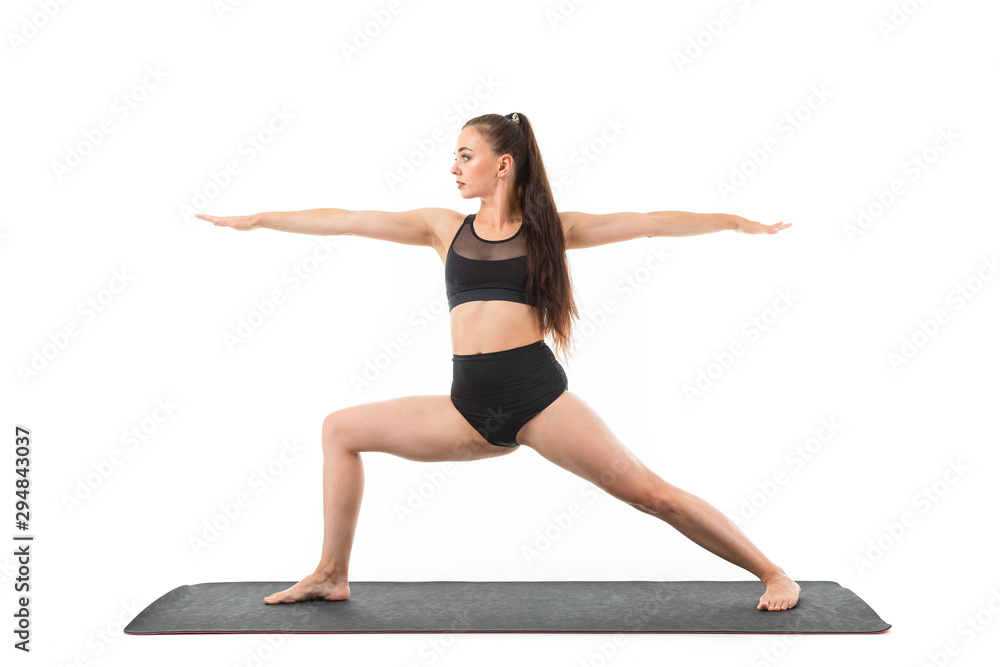 A beautiful young woman gymnast with dark long hair does warm-up and stretch her muscles.