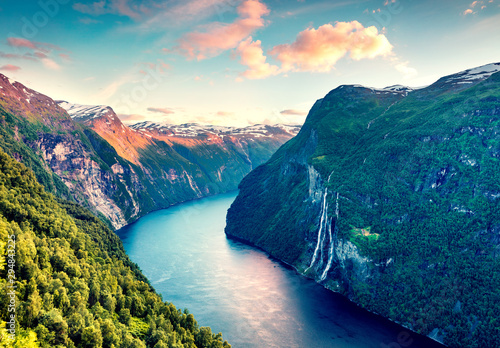 Splendid summer sunset of Sunnylvsfjorden fjord canyon, Geiranger village location, western Norway. Aerial evening view of famous Seven Sisters waterfalls. Beauty of nature concept background. photo