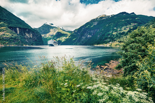Gloomy summer scene of Geiranger port, western Norway. Colorful view of Sunnylvsfjorden fjord. Traveling concept background. Artistic style post processed photo. © Andrew Mayovskyy