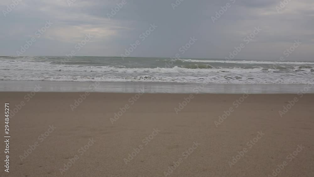 Sea waves on sandy beach during cloudy spring day Sea waves on sandy beach during cloudy spring day