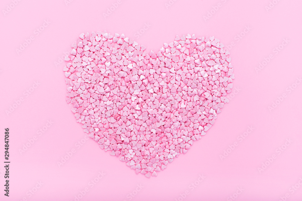 Pink background. Pink hearts on a pink background. Hearts sprinkles. Flat lay style. Top view. Sweet background. Confetti.