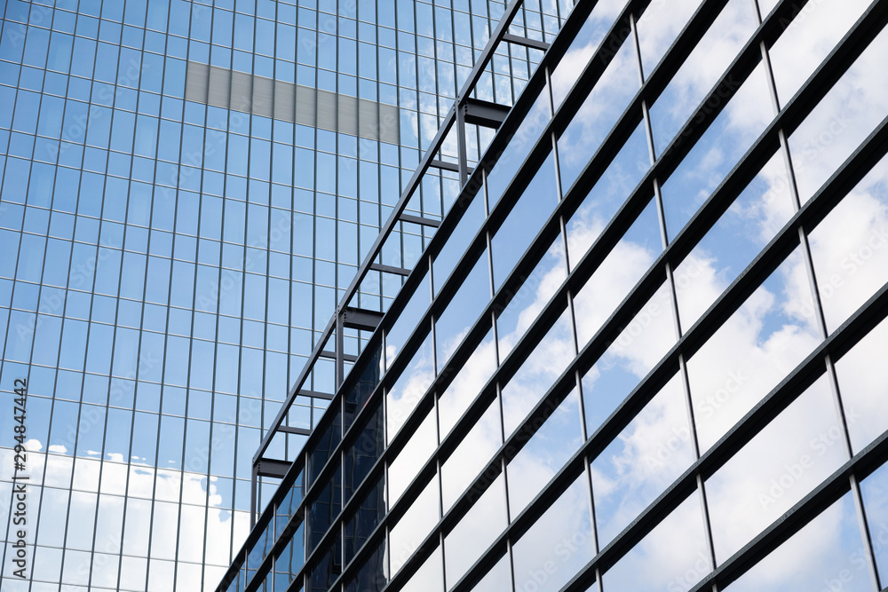Obraz premium Tall glass building of business centre reflecting blue sky