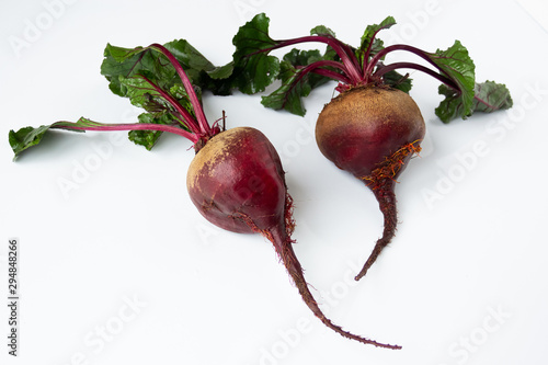 Two Fresh raw beets with tops close-up on a white background