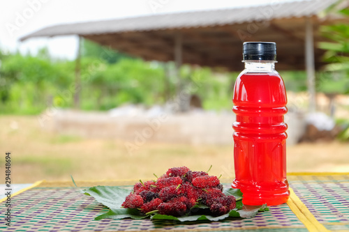 Refreshing mulberry juice in the bottles with berries on table, Healthy fruit, Organic fresh.-Healthy concept.