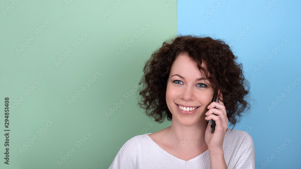 Fototapeta premium A young girl with curly dark hair. Face close-up.
