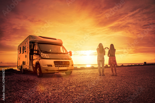 Glückliches Paar mit Wohnmobil am Strand
