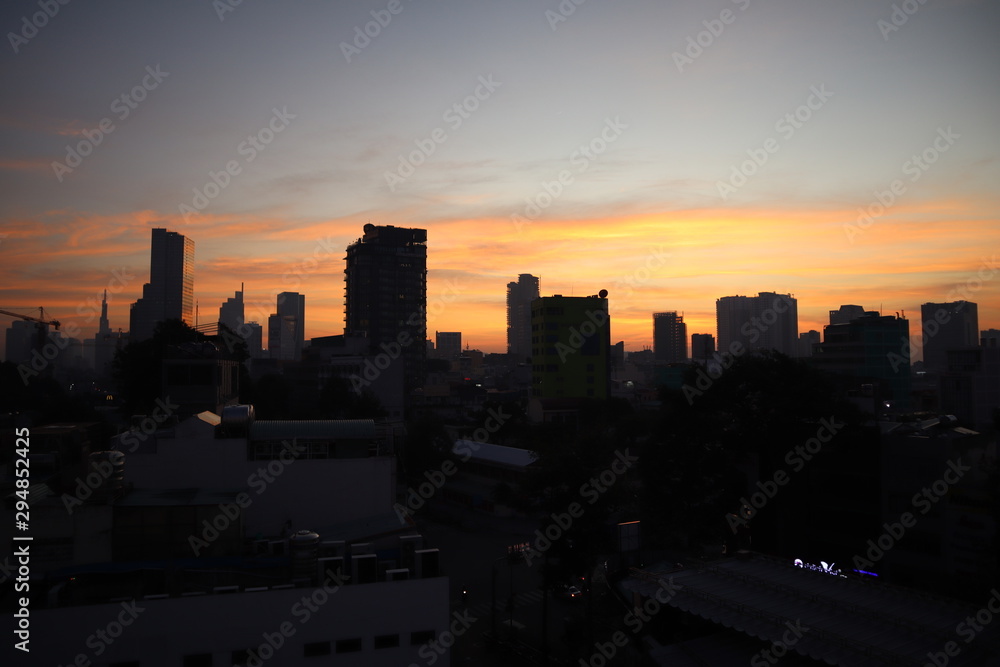 Beautiful city sunset scene and tall buildings silhouette at the background of Saigon city, Vietnam.