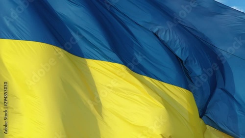 4k Ukrainian yellow blue flag, blue sky background, closeup, photo