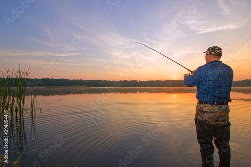 Angler catching fish during sunrise