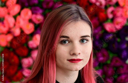 Close-up portrait of a pretty girl with colored hair on a colorful background.