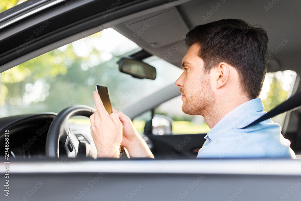 transport, vehicle and technology concept - smiling man or driver driving car and using smartphone transport, vehicle and technology concept - smiling man or driver driving car and using smartphone