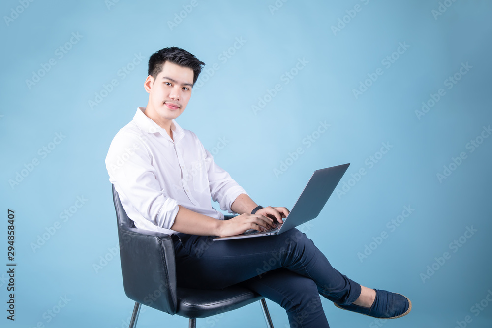 close up happy asian man online with laptop shopping business. on blue background. 