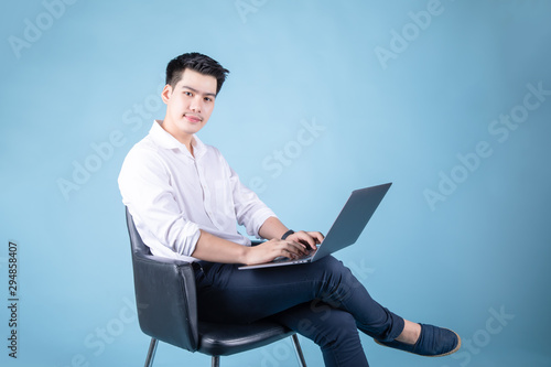 close up happy asian man online with laptop shopping business. on blue background. 