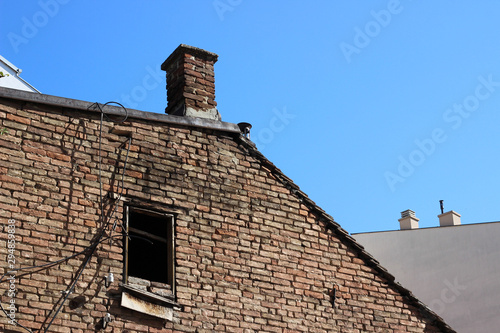 Old abandoned brick house exterior wall exposed without plaster