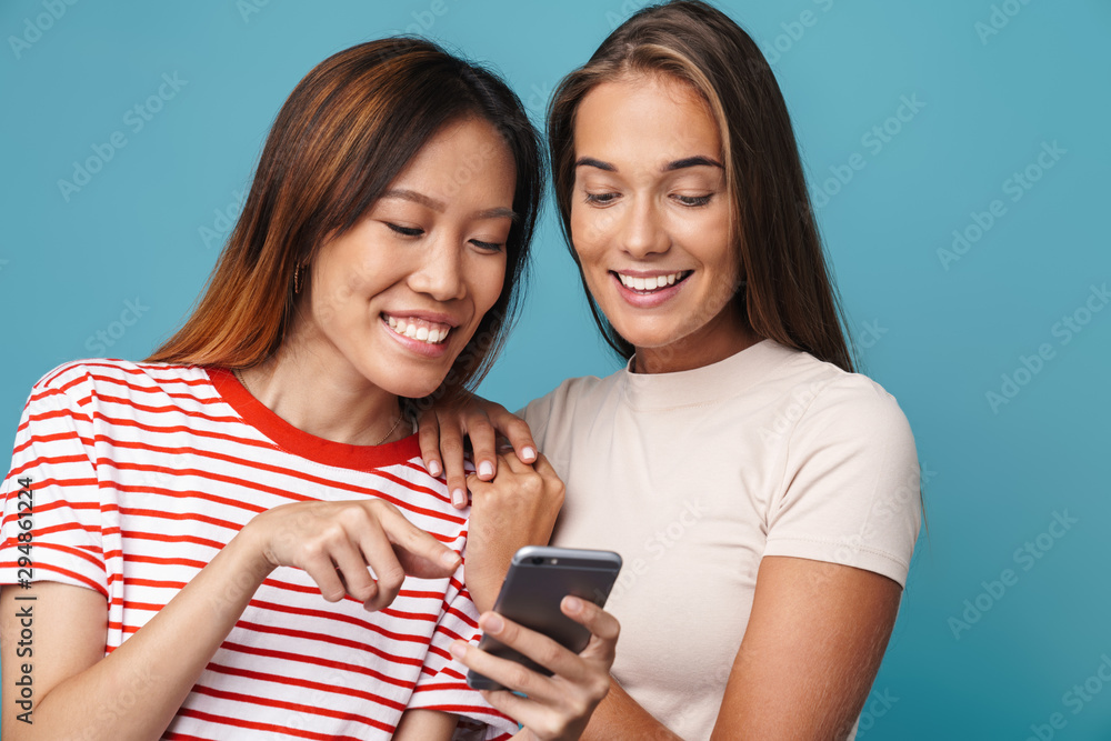 Fototapeta premium Portrait of multinational beautiful women smiling and using cellphone
