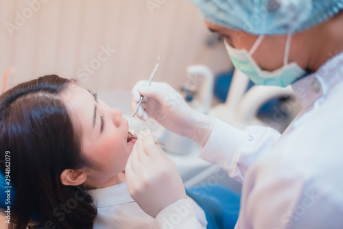 Attractive young woman in stomatology clinic with male dentist. Healthy teeth concept.