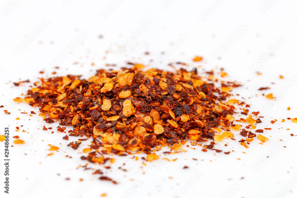 pile crushed red cayenne pepper, dried chili flakes and seeds isolated on white background pile crushed red cayenne pepper, dried chili flakes and seeds isolated on white background