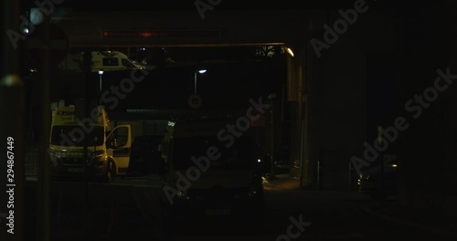 Ambulances Parked at a Emergency A&E. Late at Night As Traffic Passes By. Busy Road Ahead With Very Little Street Lights. Preparing For An Emergency.