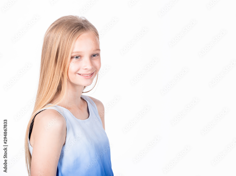Obraz premium Charming happy young girl introducing herself to new classmates. Portrait of a pleased carefree adorable daughter with blond hair in white-blue blouse, standing casually and smiling friendly.