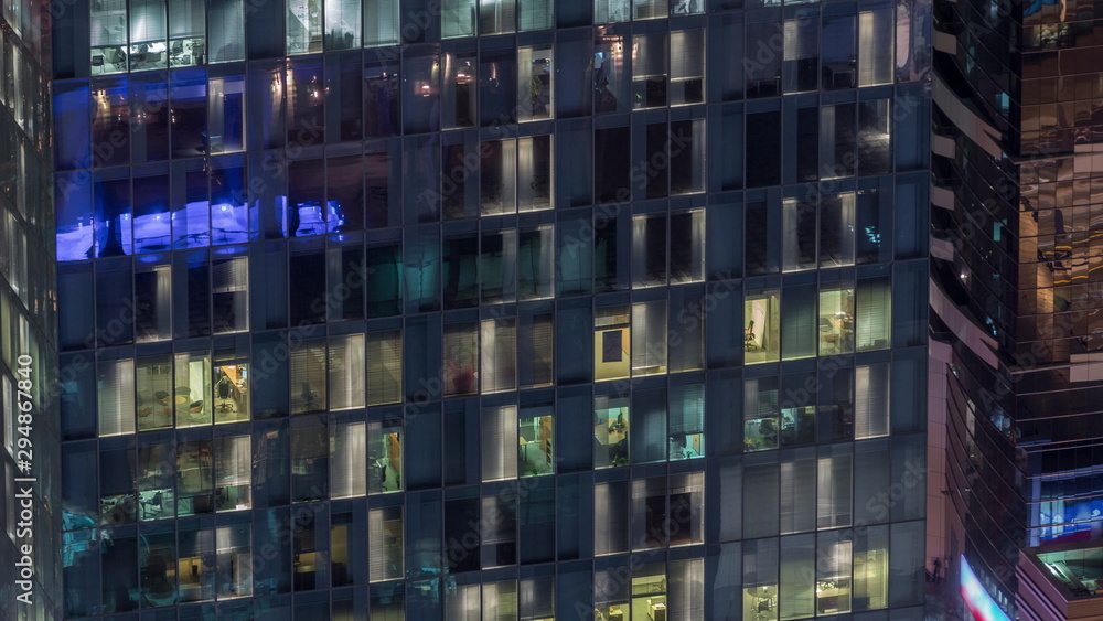 Night view of exterior apartment tower timelapse. High rise skyscraper with blinking lights in windows