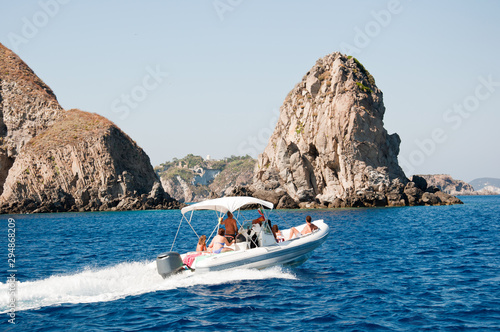 Motor boat at sea. Faraglioni and rocks of the island of Ponza (Italy). Concept of a family on vacation. © tigrom