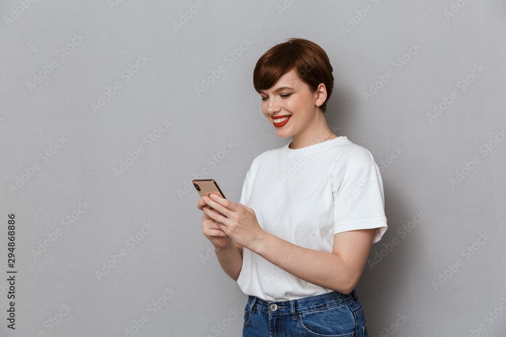 Image of caucasian young woman smiling and holding cellphone Image of caucasian young woman smiling and holding cellphone