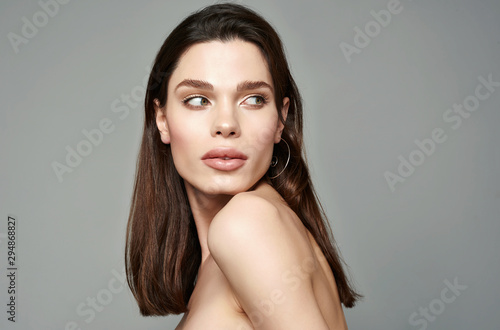 Glamour portrait of beautiful brunette woman model with fresh daily makeup and romantic hairstyle. Fashion shiny highlighter on skin, sexy gloss lips make-up and dark eyebrows.