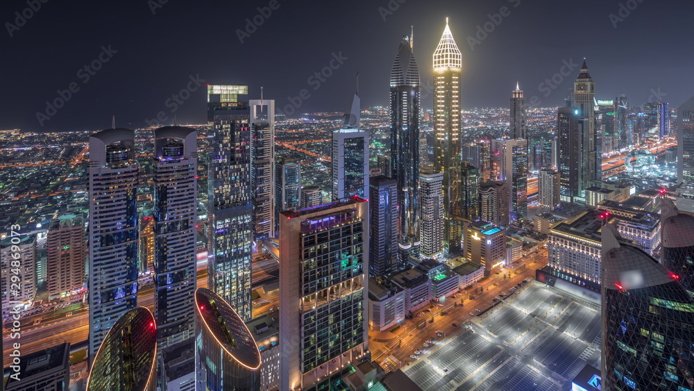 Naklejka premium Skyline of the buildings of Sheikh Zayed Road and DIFC aerial night timelapse in Dubai, UAE.