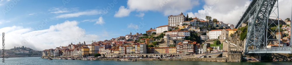 Panoramic view of the Douro River snaking through the city of Porto with the Ponte Luiz bridge in the foreground taken at a low level.