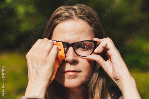 Woman cleaning eyeglasses