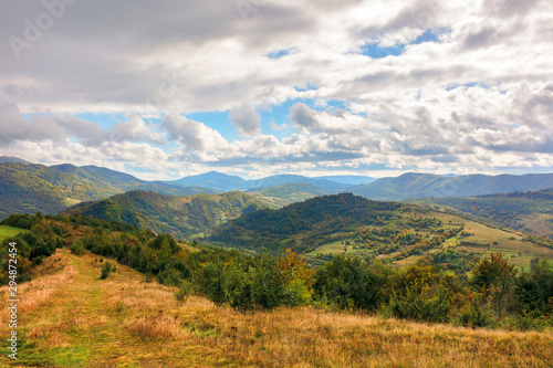 wonderful autumn scenery in mountains. beautiful countryside with forested hills and gorgeous afternoon sky with clouds