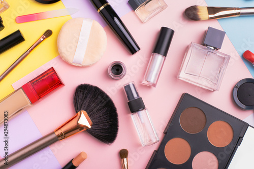 Makeup products and cosmetics on multi color background, flat lay. Fashion and beauty blogging concept. Top view