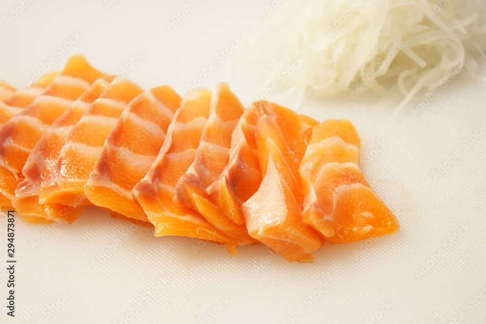 salmon sashimi on cutting board with radish Shredded salmon sashimi on cutting board with radish Shredded