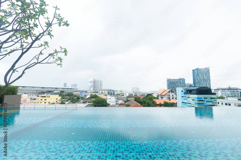 swimming pool at top of hotel and urban view , cityscape relax background .