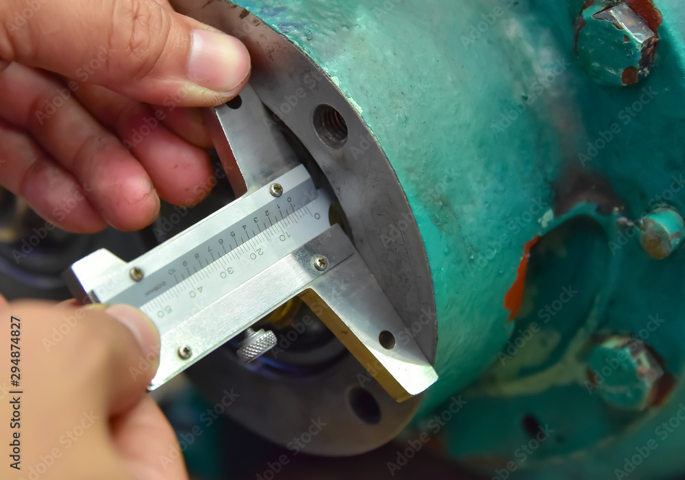 Technician measuring the depth of work piece by depth micrometer.Depth