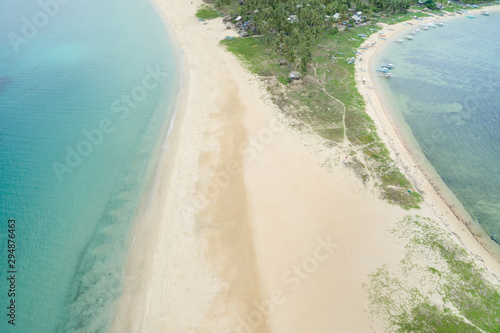 A narrow isthmus with a clean white sand beach and some dunes photo