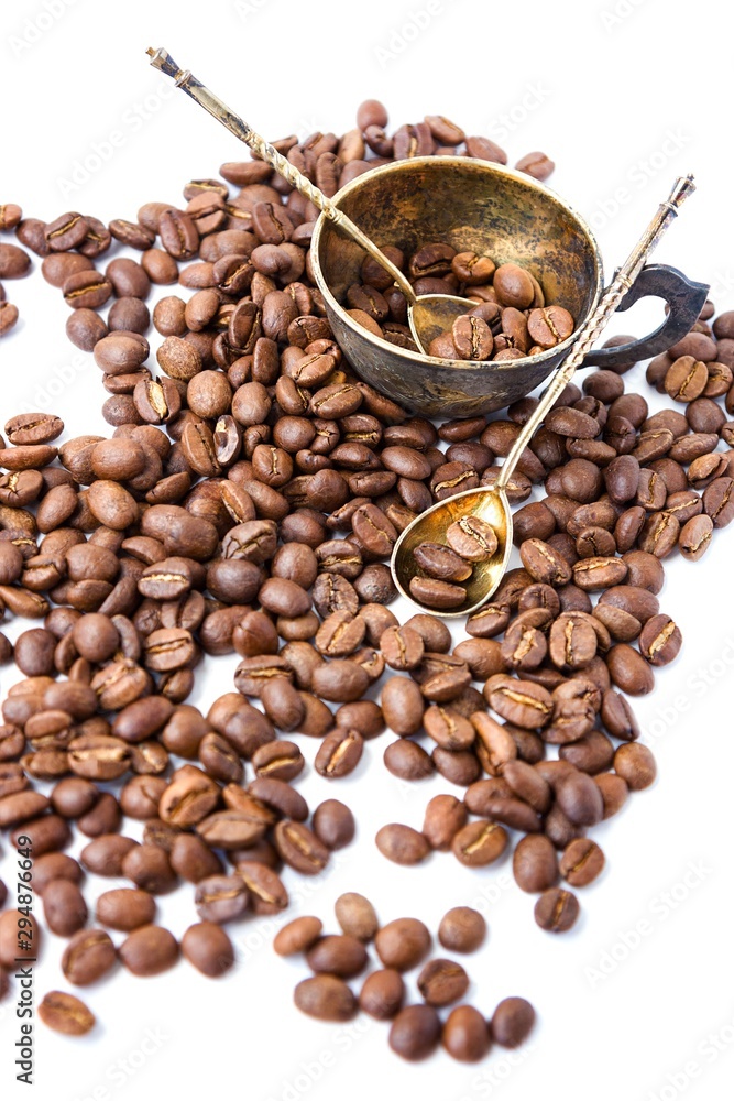 Coffee beans and antuque cup and spoons on white background