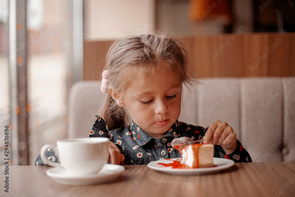 Little girl eating cake in cafe Little girl eating cake in cafe