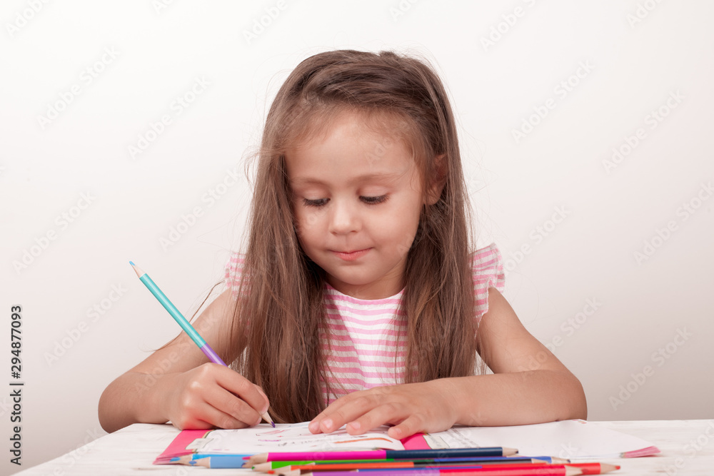 The girl draws in colored pencils The girl draws in colored pencils
