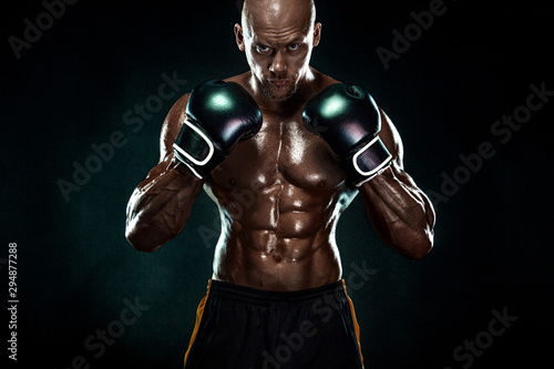 Sportsman, man boxer fighting in gloves on black background. Fitness and boxing concept. Individual sports recreation. © Mike Orlov