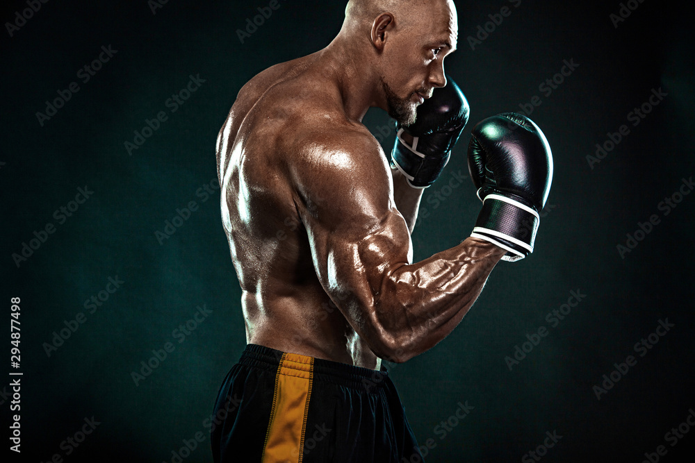 Sportsman, man boxer fighting in gloves on black background. Fitness and boxing concept. Individual sports recreation.