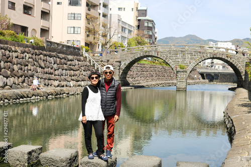Senior couple posing at Meganebashi Bridge in Nagasaki, Japan. Meganebashi bridge is tourist attraction. photo