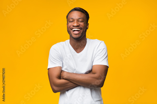 Black Man Laughing Crossing Hands Looking At Camera, Studio Shot