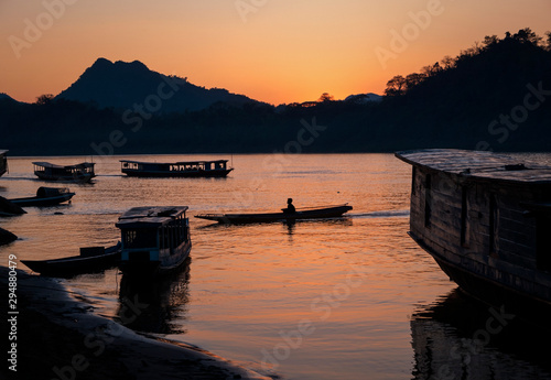Fototapeta Naklejka Na Ścianę i Meble -  Local ferry boats in the Mekong River at sunset, Luang Prabang, Laos
