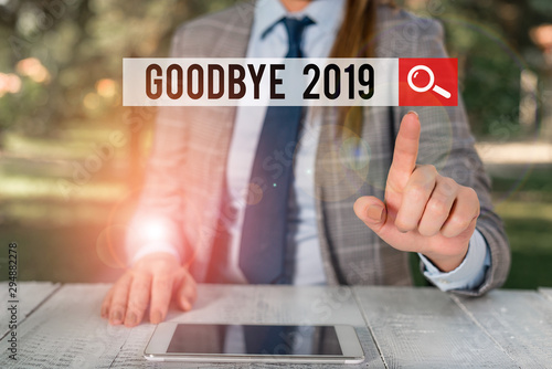 Word writing text Goodbye 2019. Business photo showcasing expressing good wishes during parting at the end of the year Female business person sitting by table holding mobile phone