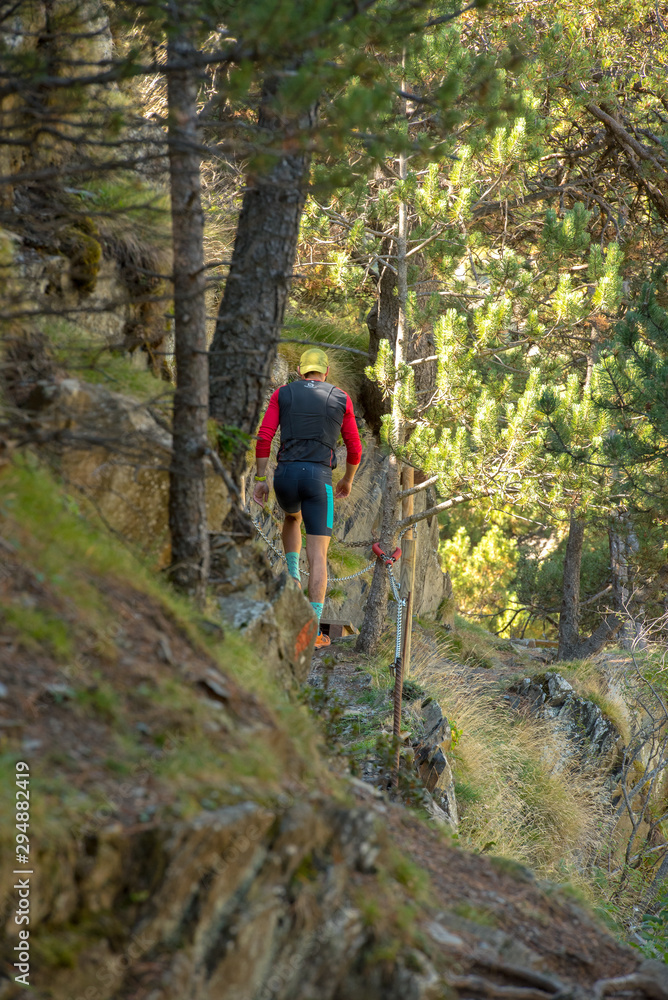 Fototapeta premium MAN TRAINS RUNNING THROUGH THE MOUNTAIN IN THE PYRENEES OF Andorra.