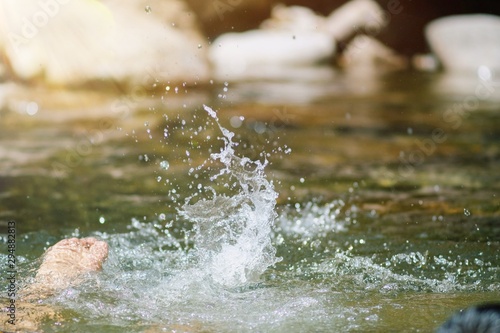 Outdoor lifestyle of Little children enjoying swimming at mountain stream with splashing of water in summertime.
