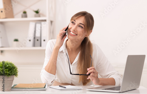 Happy Office Girl Talking On Mobile Phone Sitting At Workplace