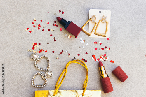 gift bag, lipsticks and beautiful earrings decorated with heart confetti
