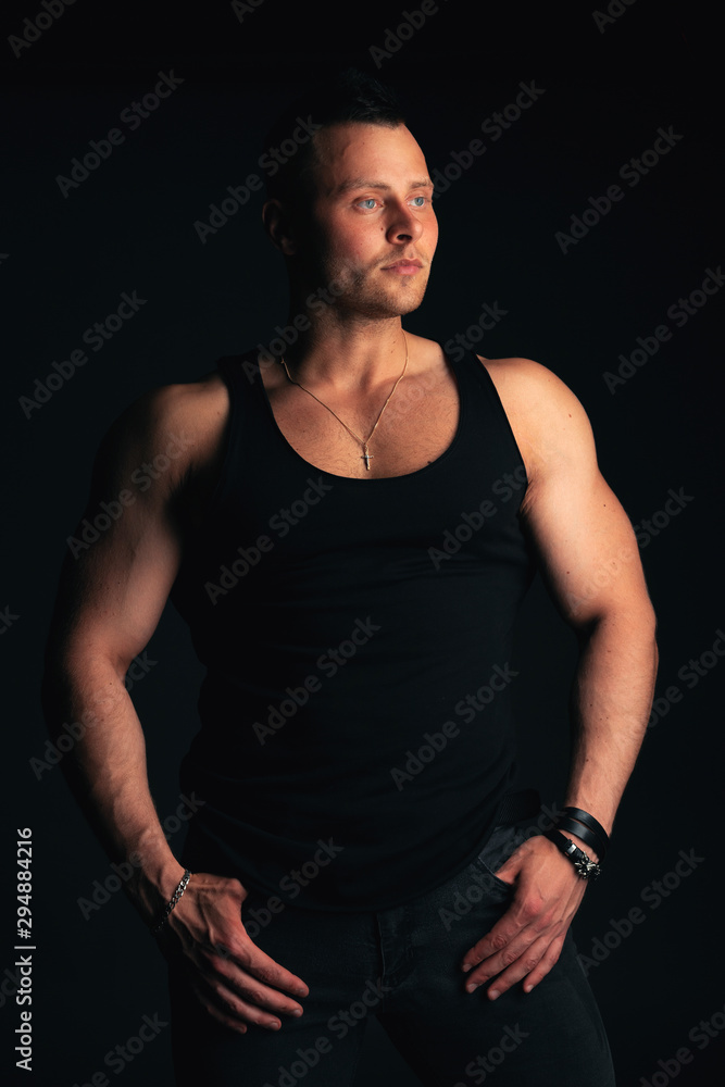 Strong and handsome young man with muscles and biceps. Studio shooting on black background. Strong and handsome young man with muscles and biceps. Studio shooting on black background.
